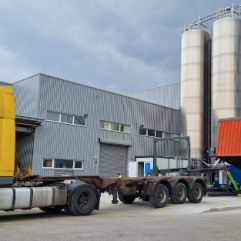 Container tipper for unloading on trailer